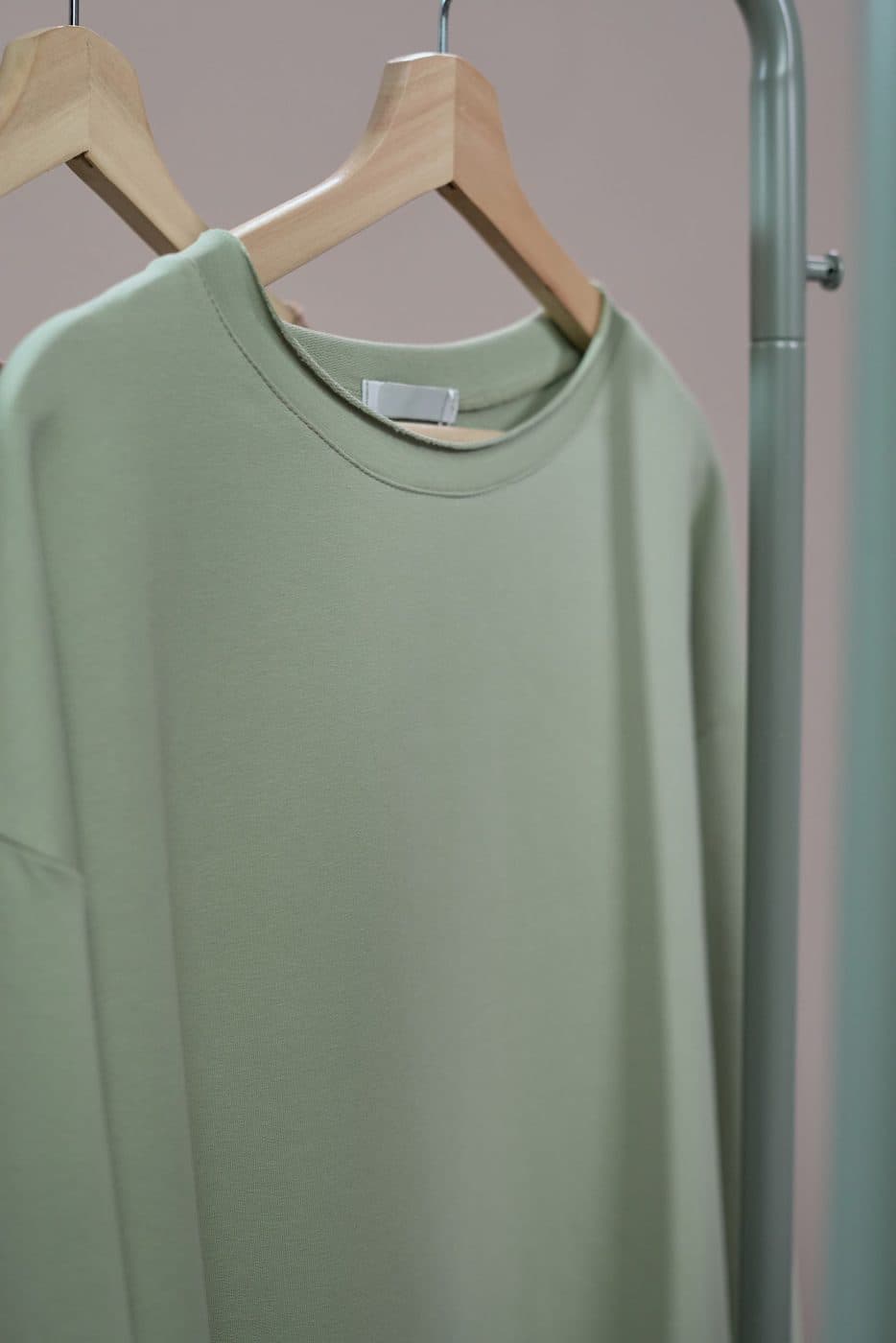 Plain crew-neck sweatshirt on a wooden hanger